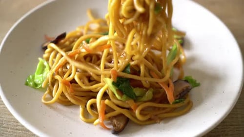 Plate of Stir-Fried Noodles with Chopsticks Close Up