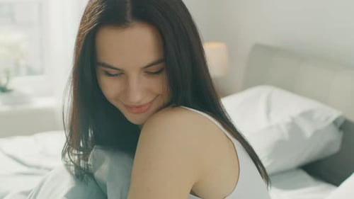 Smiling Woman Relaxing in Bed at Home