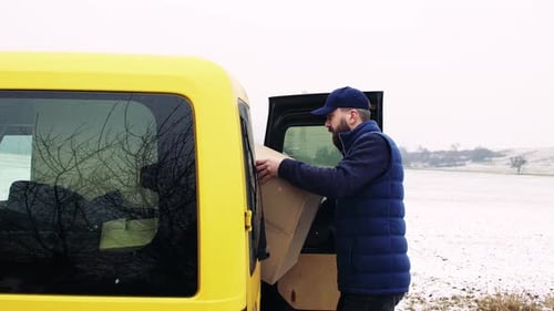 Delivery Man with Smartphone Delivering Parcel Box to Recipient
