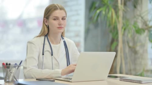 Doctor Typing on Laptop in Bright Office