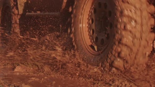 SUV Drives Forward on Off Road Splashing Mud to Sides Closeup Car Participating in Offroad Racing