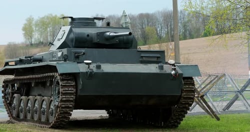 Vintage Military Tank Driving Down a Country Road