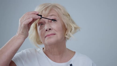 Mature Woman Applying Mascara in a Close Up Shot