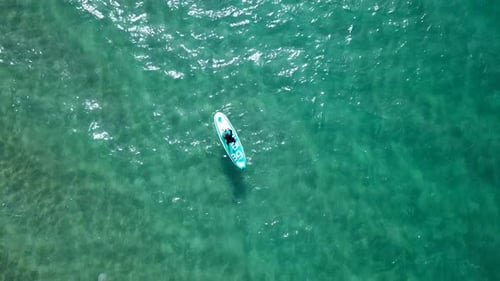 SUP surfers paddling along a Mediterranean coast