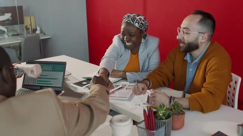 Diverse Creative Startup Team Bumping Fists at Meeting in Office