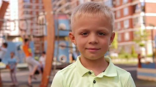 A Little Boy on the Playground in the Courtyard of a Modern Residential Complex