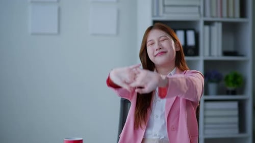 Businesswoman in pink suit working in office space.