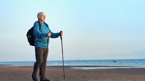 Active Grandfather Backpacker Scandinavian Walking Stick Relaxing at Sea Beach Sunset Enjoy Seascape
