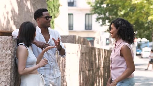 Multiethnic Friends Talking While Standing on Sidewalk in City During Daytime