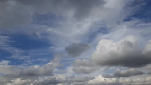 Schnelllebiger warmer Sommertag, weiße Regenwolken, die in den oberen und unteren Schichten über den Himmel ziehen, Zeit l