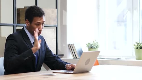 Man in Suit Using Laptop During Video Conference