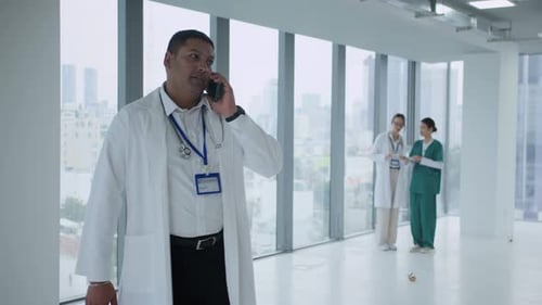 Male Nurse Discussing Patients Card with Doctor at Hall of Clinic