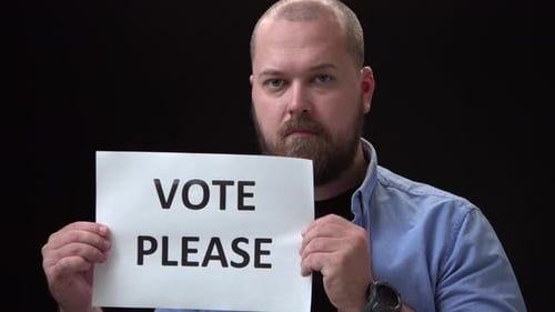 Man Holding Vote Please Sign