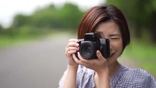 Smiling Woman with Camera Pretending to Take Photos