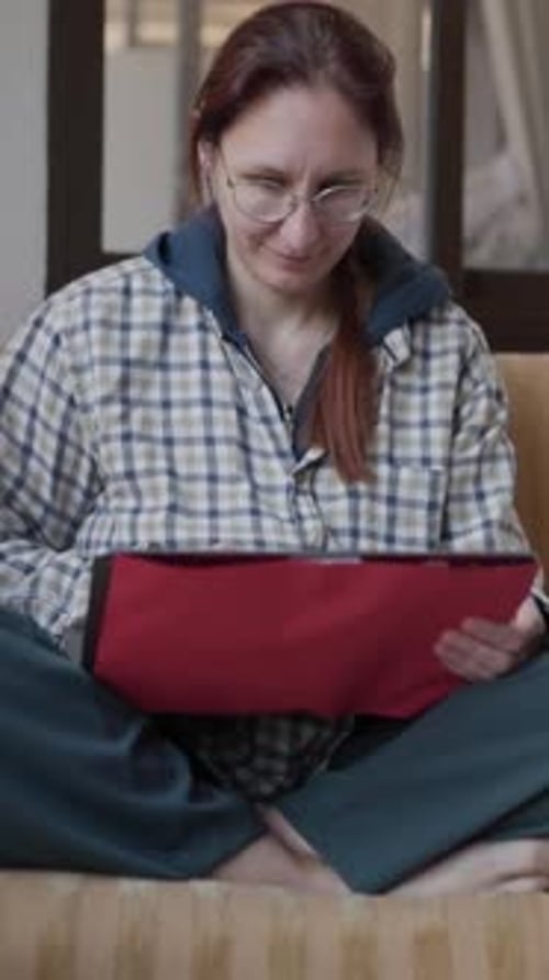 Woman Using Tablet on Sofa at Home