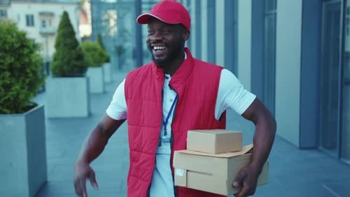 Happy Delivery Man Holding Packages on City Sidewalk