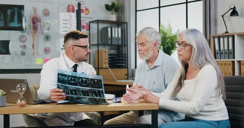 Attending physician involved in serious examines the X-ray of the older woman and discusses further