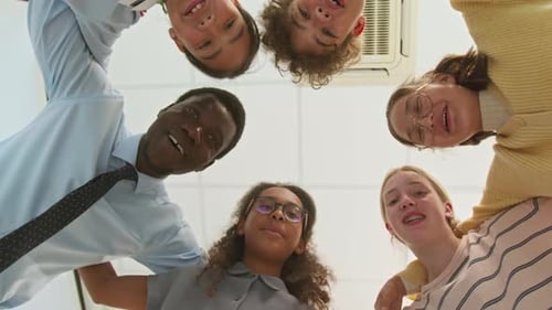 Smiling Team Puts Hands Together in a Huddle