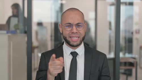 Young Adult Man Angrily Gesturing in an Office