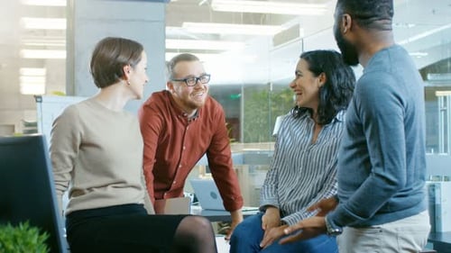 Diverse Group of Four Talented Young Professionals Having Team Building Conversation, Joking and Ha
