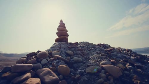 Carefully Balanced Stack of Rocks on Slate in the Desert Sun Against the Blue Sky