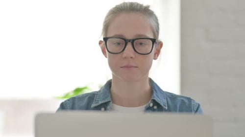 Close Up of Young Woman Working on Laptop in Office