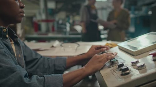 Young Black Woman Operating Machine Equipment at Factory