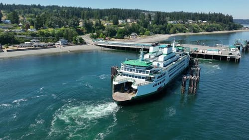 Aerial view of a docked ferry unloading vehicles.