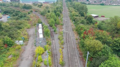 Eine Luftaufnahme von überwucherten Bahngleisen im Grünen, die zeigt, wie die Natur einst ein Bus zurückgewonnen hat