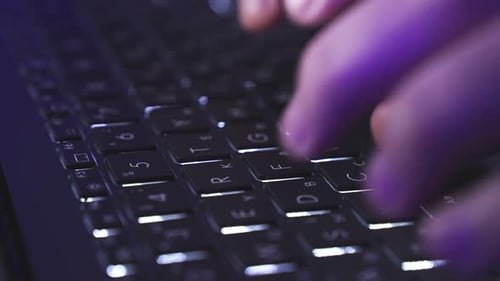 Mãos tocando o teclado do laptop no escuro no escritório doméstico Câmera lenta