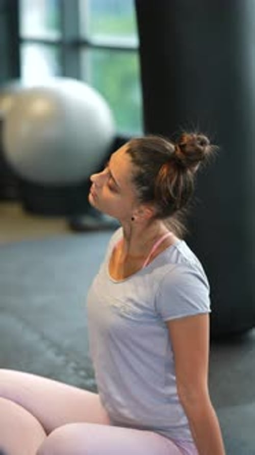 Woman Stretching Neck Muscles at the Gym