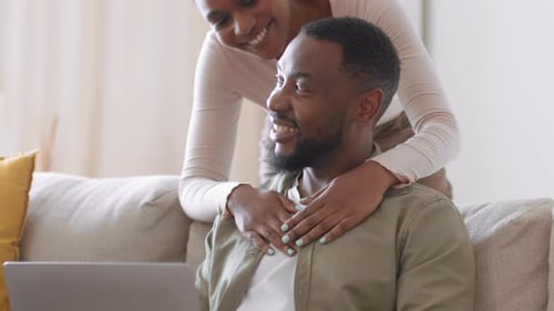 Loving Couple Using Laptop Together on Sofa