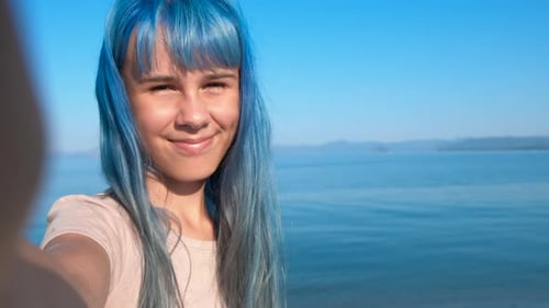 Makes Selfie on a Smartphone Against Sea