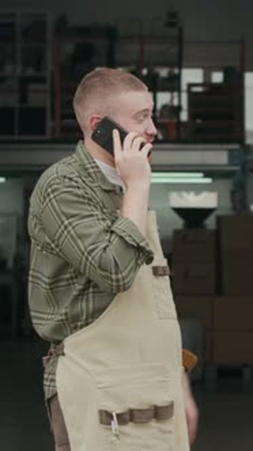 Roaster Having Animate Phone Call Conversation at Coffee Roasting Plant