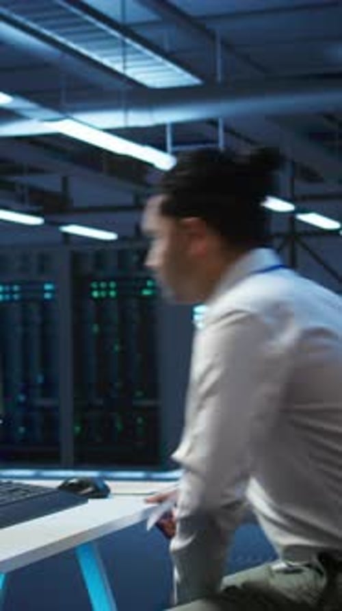 Man Works at Computer in Futuristic Server Room