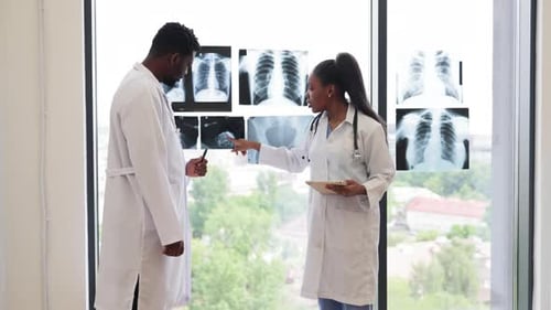 Doctors Examining and Discussing Chest Xrays Near Clinic Window