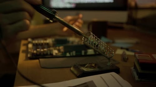 Close-up of Man Picking Up Soldering Iron, Working on Computer Motherboard