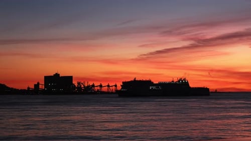 Ferry Ship Vessel Silhouette in Sea Against Dramatic Sunset Background