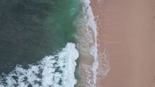 Wellen krachen auf einem rosa Strand