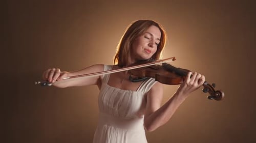 Woman in white dress playing violin beautifully