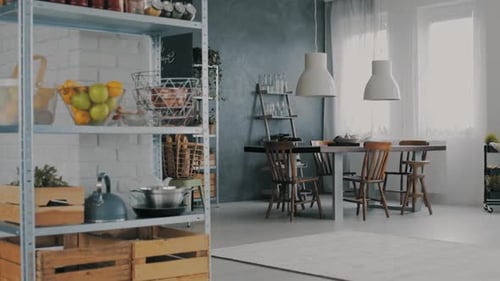 Intérieur de salle à manger tendance avec caisses en bois, fruits et bouilloire sur étagère en métal