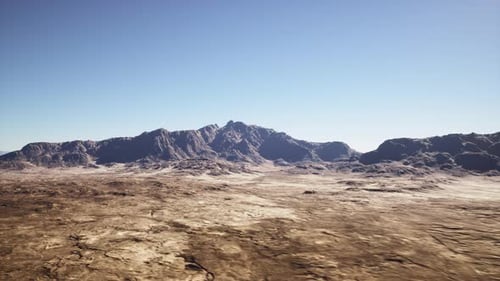 Vast Sunlit Desert with Rugged Geological Formations and Clear Horizon