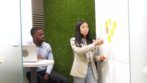 Businesswoman Using Sticky Notes on Whiteboard in Coworking Office