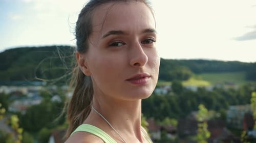 Woman Turns Toward Camera in Green Setting