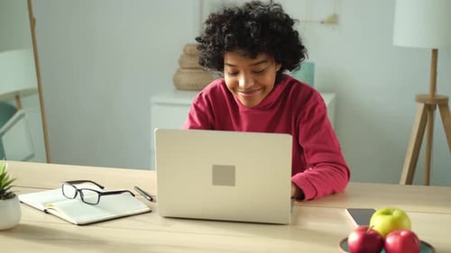 African American Girl Using Laptop at Home Office Looking at Screen Typing Chatting Reading Writing