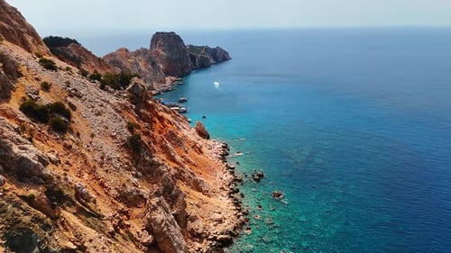 Cliffs and clear sea waters. Rocky cliffs meet vibrant blue waters under a clear sky