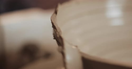 Potter au tour de potier fabrique un produit en céramique à l'aide de ses mains et de ses outils de poterie Gros plan