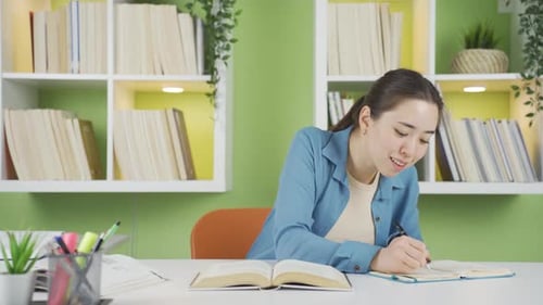 Woman Studying at Desk with Books and Notes