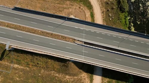 Trucks and cars driving on river bridge road expressway highway through rural landscape, Overhead ae