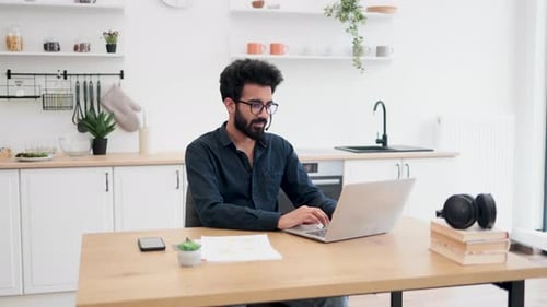 Young Adult Working At Home on Laptop